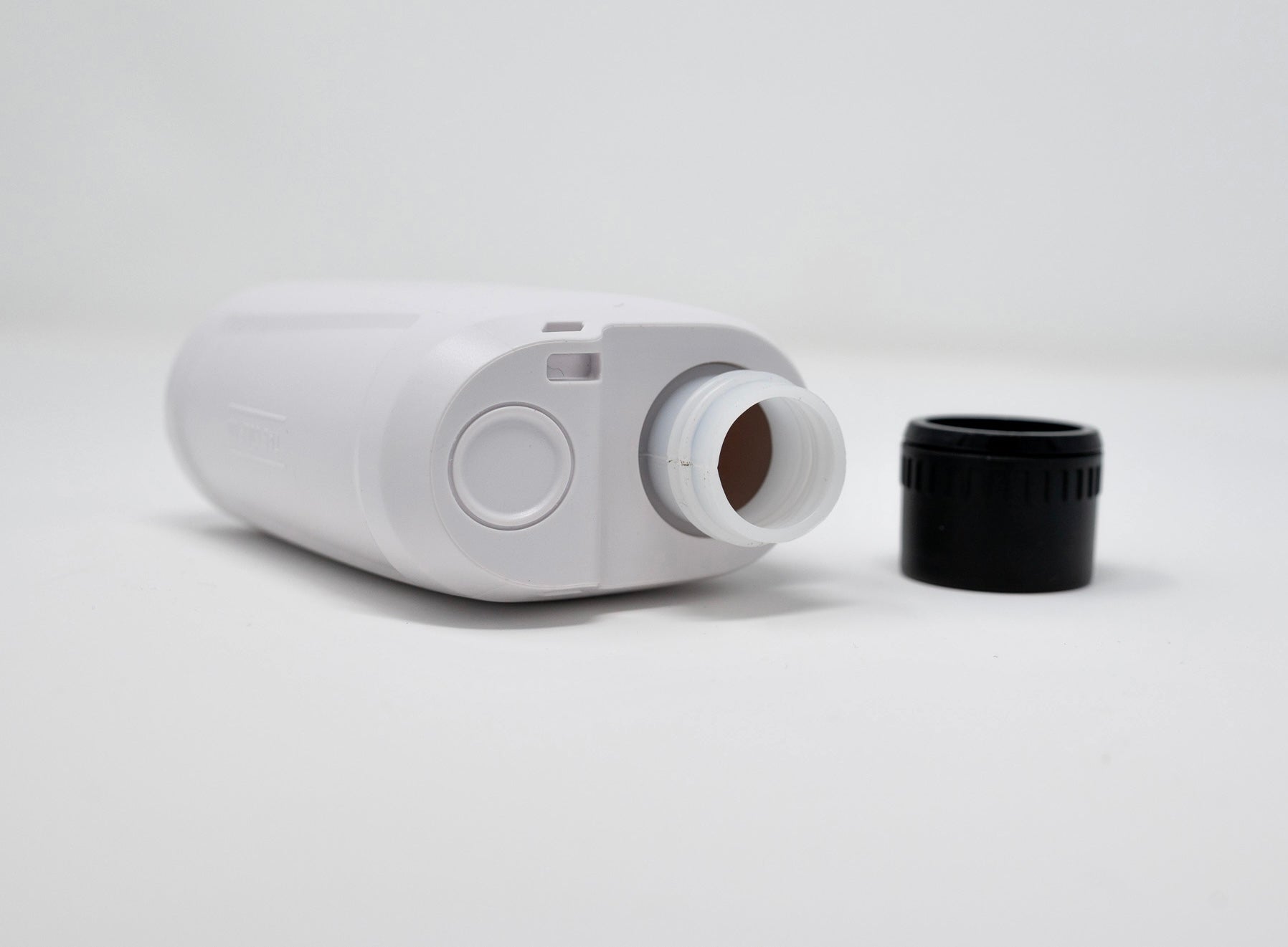 White bottle with a black cap on a white background